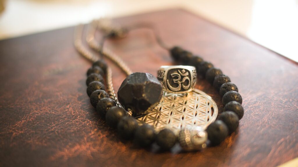 Necklace and religious symbolic pendants laying on a wooden table.